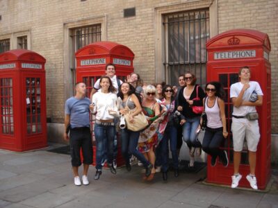 Schülergruppe vor britischen Telefonzellen